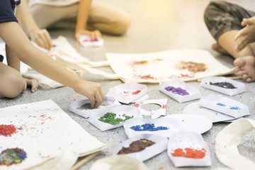 Close up hands of a kids drawing on paper  with many color