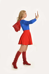 full length portrait of pretty girl wearing super hero costume, standing pose, isolated on white studio background.
