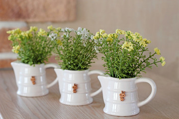  Artificial flowers in white ceramic vases on the table decorating .