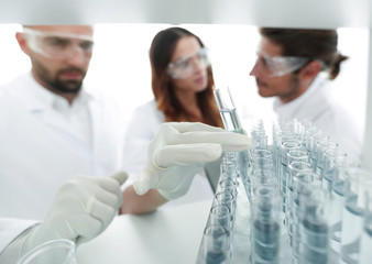 Obraz premium background image is a group of scientists studying the liquid in the glass tube.