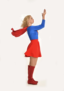 full length portrait of pretty girl wearing super hero costume, standing pose, isolated on white studio background.
