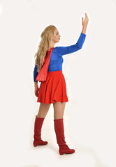 full length portrait of pretty girl wearing super hero costume, standing pose, isolated on white studio background.