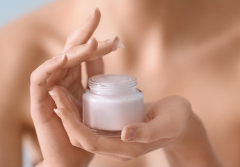 Young woman with jar of hand cream, closeup
