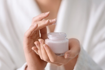 Young woman with jar of hand cream, closeup