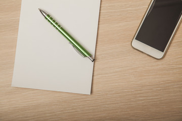 wooden desk with a notebook, top view, empty paper 