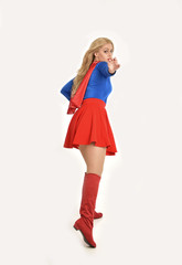 full length portrait of pretty girl wearing super hero costume, standing pose, isolated on white studio background.