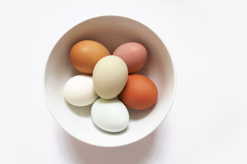 Bowl of natural colourful eggs top view