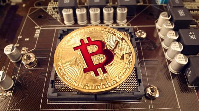 Gold Bit Coin BTC coins on the motherboard. Bitcoin is a worldwide cryptocurrency and digital payment system called the first decentralized digital currency.