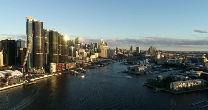 Barangaroo modern urban towers in Sydney cityscape on Darling Harbour waterfront in aerial flying over harbour waters towards Pyrmont.
