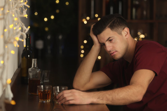 Young drunk man in bar. Alcoholism problem