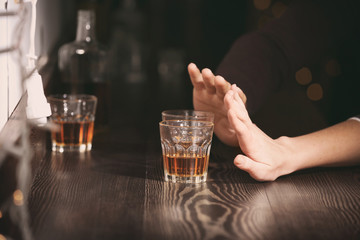 Woman refusing to drink alcohol in bar, closeup