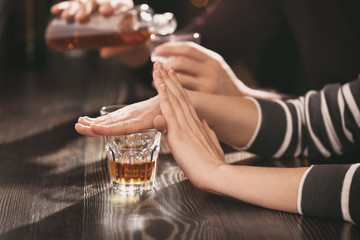 Woman refusing to drink alcohol in bar