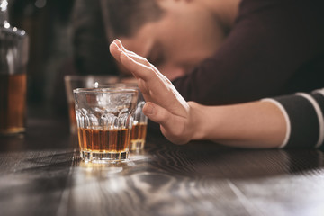 Woman refusing to drink alcohol in bar, closeup