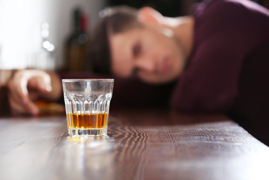 Drunk man with glass of drink in bar. Alcoholism problem