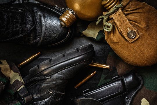 Army uniform military boots, boots, pants, bowler, pistol in holster on a dark background with copy space workspace flat lay top view