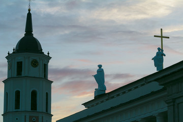 Sculpture silhouettes of Saint Helena and Saint Casimir on Cathedral Basilica of St. Stanislaus and St. Ladislaus roof and Cathedrals Belfry tower in Vilnius Lithuania at dusk