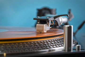 Fototapeta na wymiar Turntable needle on orange colored vinyl record