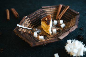 Cake on a wooden tray on a black matte background