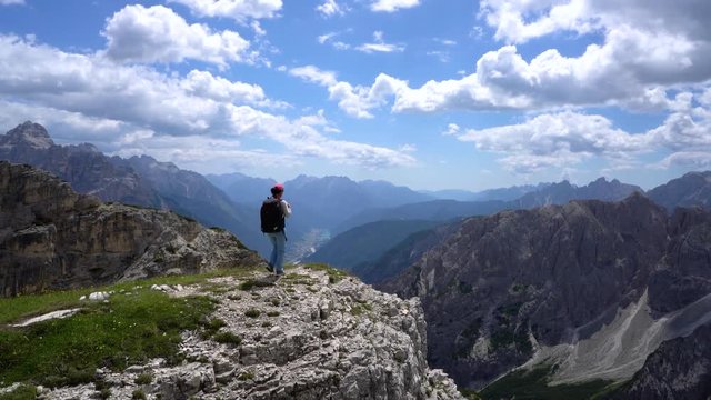 Hiker woman standing up achieving the top Dolomites Alps.
