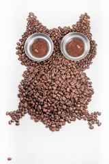 Owl made of roasted coffee beans isolated on white wooden background