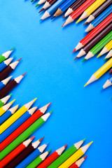 Colored pencils background.Color pencils on blue background.Close up. Many different colored pencils on blue background.Colorful pencil .Colorfull Macro shot of color pile pencil nibs