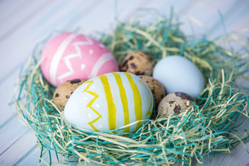 Colorful bright hand painted Easter eggs in a nest. Holiday spring card