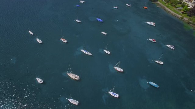 UDH Lake Geneva aerial shot - City of Morges. Camera tilting up to discover the boats and the city in the background