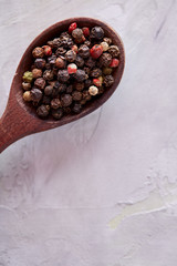 Conceptual composition of salt and pepper on spoons and bowls over light background, top view, close-up