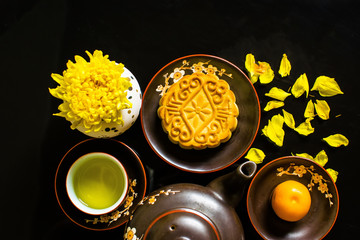 Mooncake and tea, Chinese mid autumn festival food isolated on black background.