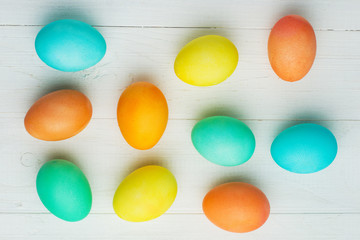colored Easter eggs on a white table, top view