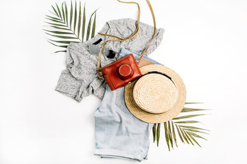Woman fashion travel. Retro camera, straw, shorts, sunglasses and tropical palm leaf. Top view, flat lay.