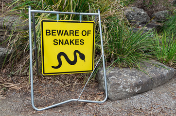 Obraz premium Yellow beware of snakes warning sign in suburban Melbourne.