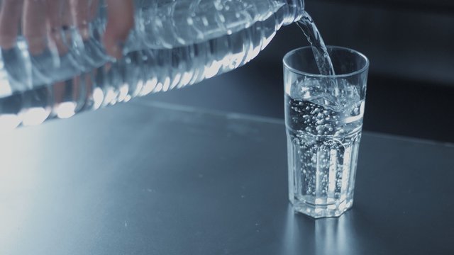 closeup slowmotion of glass fulling with water bubble floating