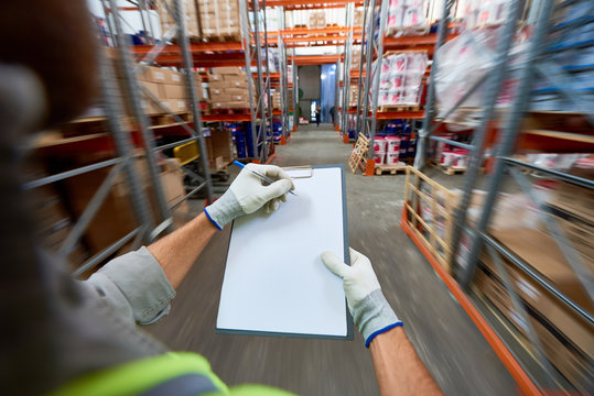 High Angle Close Up Of Workers Hands Holding Clipboard With Documentation Standing In Modern Warehouse, Copy Space