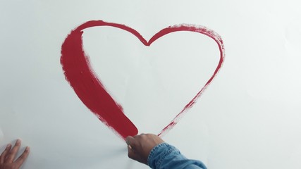 man drawing red heart top view