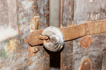 Old round padlock on old rusty door