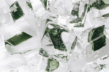 Flat lay of ice cubes with frozen aloe inside on white wooden table
