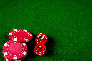 poker chips and dice on green background top view