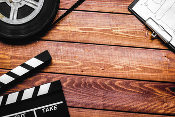 Screenwriter desktop with movie clapper board wooden background 