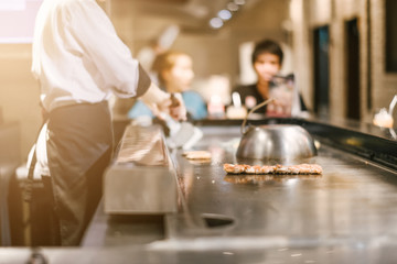 Hand of man take cooking of meat with vegetable grill, Chef cooking wagyu beef in Japanese teppanyaki restaurant