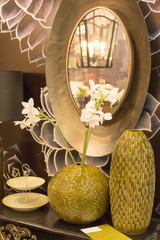 a part of luxurious interior with two vases and mirror in the golden frame