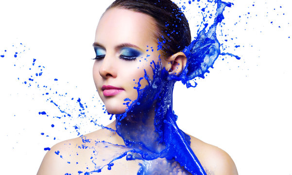 Beautiful girl and blue paint splashes isolated on white