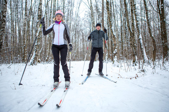 Image of sports woman and man skiing in winter forest
