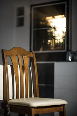 Wood dinner chair in house and sunlight on sunset.