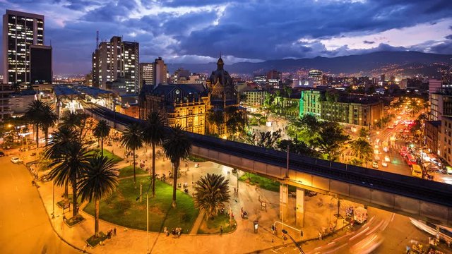 Medellin, Colombia, time lapse view of downtown buildings and Plaza Botero square at dusk.