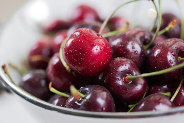 Cherries on wooden table with napkin and water drops macro background