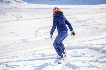 Fototapeta na wymiar Photo from back of woman snowboarding
