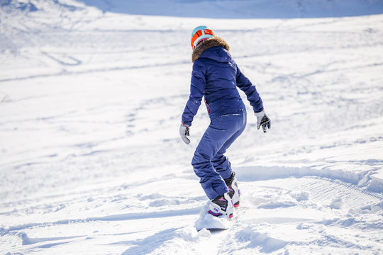 Photo from back of woman snowboarding