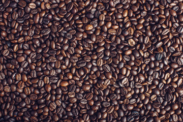 Textured background of coffee beans top view. Concept of the production of fresh aromatic drink.