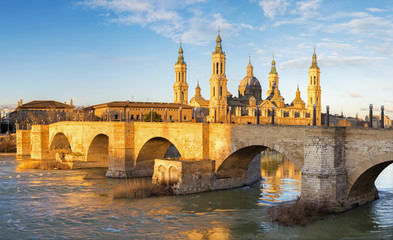 Fototapeta na wymiar Zaragoza - The bridge Puente de Piedra and Basilica del Pilar in morning light.